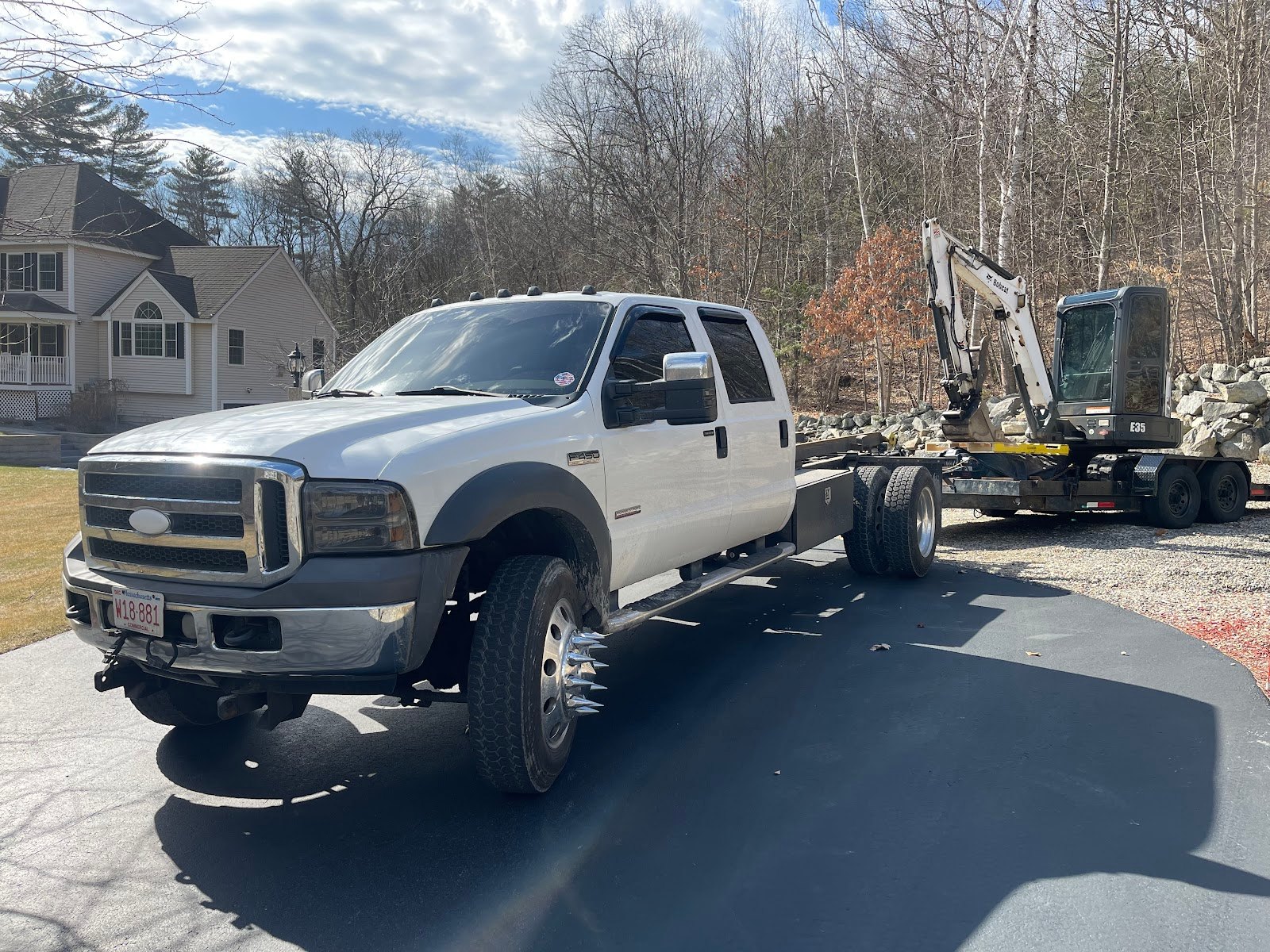 Santos and Sons truck with the company excavator loaded on its own trailer