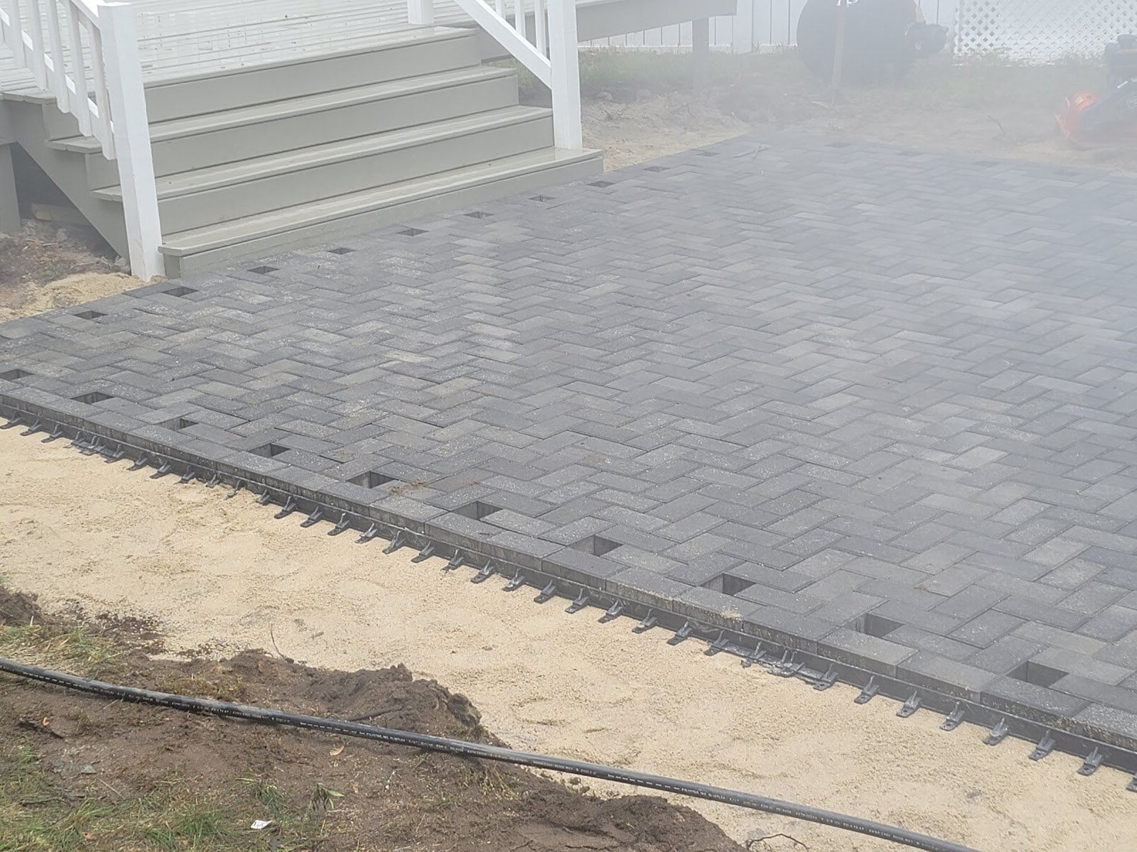 Paver walkway laid alongside a home by Santos and Sons