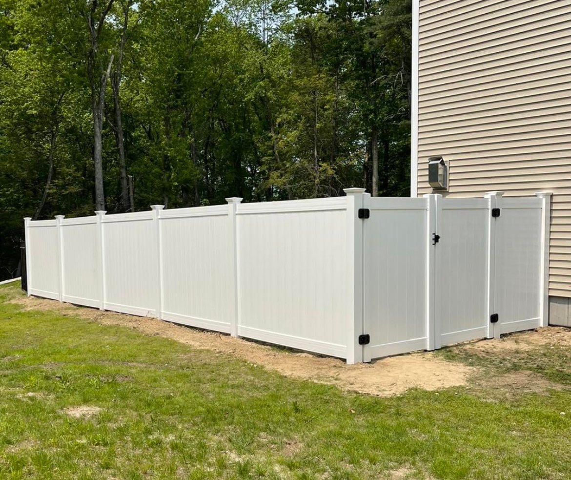 White vinyl privacy fence installed around a back yard by Santos and Sons